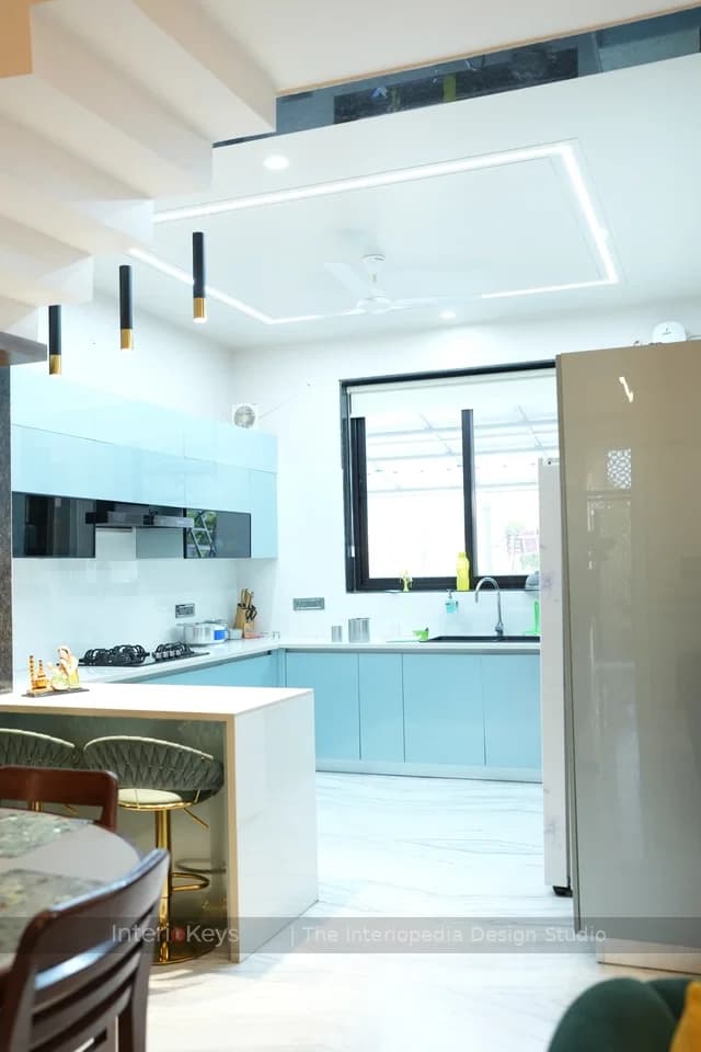 Blue Kitchen with Peninsula Counter and Brass Pendants